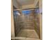 Modern shower with glass doors, neutral tile, and a small window for natural light at 1725 W Pollack St, Phoenix, AZ 85041