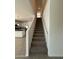 Bright stairway leading to the upper level, with a glimpse of the modern kitchen and tile flooring at 1725 W Pollack St, Phoenix, AZ 85041