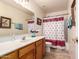 A well-lit bathroom featuring a wood vanity, framed mirrors, and a shower with curtain at 1802 W Encinas St, Gilbert, AZ 85233