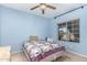 Cozy secondary bedroom with a quilt bed, ceiling fan, neutral carpeting, and a window at 1802 W Encinas St, Gilbert, AZ 85233