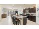 Modern kitchen featuring a granite island with seating, dark cabinets, and stainless-steel appliances at 18711 W Farmer Rd Rd, Buckeye, AZ 85326