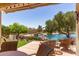 Inviting backyard patio overlooking a serene pond with mature trees at 19822 N 108Th Ave, Peoria, AZ 85373