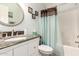 Cozy bathroom with a round mirror, granite countertop, and a shower with a curtain at 19822 N 108Th Ave, Peoria, AZ 85373