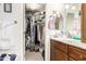 Walk-in closet connecting to a well-lit bathroom with granite counters at 19822 N 108Th Ave, Peoria, AZ 85373