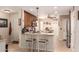 Well-lit kitchen with white chairs, island, stainless steel appliances, and warm wooden cabinetry at 19822 N 108Th Ave, Peoria, AZ 85373
