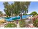 Relaxing backyard view of a shimmering lake, mature trees, and well-maintained landscaping at 19822 N 108Th Ave, Peoria, AZ 85373