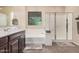 Bathroom featuring a combined shower and tub, with brown cabinets and a decorative frosted glass window at 20211 N Winter Escape Ct, Maricopa, AZ 85138