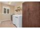 Well-organized laundry room with white appliances, cabinetry, and a bright window at 20211 N Winter Escape Ct, Maricopa, AZ 85138