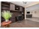 Home office space featuring a built-in desk, dark cabinetry, and hardwood floors at 20211 N Winter Escape Ct, Maricopa, AZ 85138