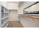 Spacious walk-in closet featuring custom shelving, hanging rods, and a mirror for ample storage and convenience at 20211 N Winter Escape Ct, Maricopa, AZ 85138
