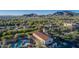 Community clubhouse and pool area are surrounded by palm trees, with a mountain view and hot air balloons in the distance at 20872 W Thomas Rd, Buckeye, AZ 85396