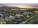 Wide aerial view showcases a well-planned community with lush landscaping, mountain views, and solar panels at 20872 W Thomas Rd, Buckeye, AZ 85396