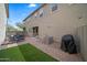 Backyard featuring artificial turf, a brick patio, and outdoor seating, perfect for relaxation and entertaining at 20872 W Thomas Rd, Buckeye, AZ 85396