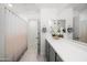 Bright bathroom features a large mirror, neutral color palette, and shower with a stylish curtain at 20872 W Thomas Rd, Buckeye, AZ 85396