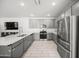 Beautiful kitchen featuring stainless steel appliances, gray cabinets, and stone countertops at 20872 W Thomas Rd, Buckeye, AZ 85396