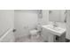 Clean powder room featuring a pedestal sink, toilet, and simple decor, perfect for guests at 20872 W Thomas Rd, Buckeye, AZ 85396