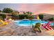Stunning backyard pool with a firepit, spa, and beautiful patio furniture under a colorful dusk sky at 22323 E Via Del Jardin --, Queen Creek, AZ 85142