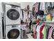 This walk-in closet features a washer and dryer and lots of clothing on racks at 22323 E Via Del Jardin --, Queen Creek, AZ 85142