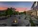 Outdoor oasis with a built-in BBQ, fire pit, and covered patio overlooking the pool and lush landscaping at 2282 E Zion Way, Chandler, AZ 85249