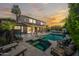 Backyard featuring a sparkling pool, spa, travertine tile, and outdoor lounge area at dusk at 2282 E Zion Way, Chandler, AZ 85249
