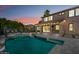 Backyard pool view with travertine tile deck, covered patio, and lush landscaping at twilight at 2282 E Zion Way, Chandler, AZ 85249