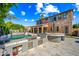 Outdoor kitchen area with marble tile, large BBQ, and serving area alongside a luxurious pool for the ultimate backyard at 2282 E Zion Way, Chandler, AZ 85249