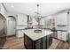 Island kitchen boasting stainless appliances, stylish lighting, black countertops, and white cabinetry with a backyard view at 2282 E Zion Way, Chandler, AZ 85249