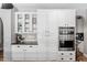 Bright kitchen with stainless ovens, glass display cabinets and stylish white cabinetry at 2282 E Zion Way, Chandler, AZ 85249