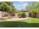 Beautiful backyard featuring stone patio, lush landscaping, mature trees, and a cozy outdoor dining area at 2313 S Grandview Ave, Tempe, AZ 85282