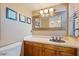 Bathroom vanity with marble countertops, bronze fixtures, and decorative mirror at 2313 S Grandview Ave, Tempe, AZ 85282
