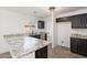 Well-lit kitchen with granite countertops, modern appliances, and black cabinetry at 23772 W Grove St, Buckeye, AZ 85326