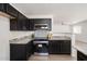 Modern kitchen equipped with black cabinets, granite countertops, and stainless steel appliances at 23772 W Grove St, Buckeye, AZ 85326