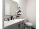 Modern powder room features a gray vanity, a white porcelain sink, and modern fixtures at 23772 W Grove St, Buckeye, AZ 85326
