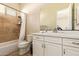 Modern bathroom featuring a bathtub, shower with travertine tile, and a white vanity at 2457 E Melrose St, Mesa, AZ 85213