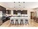 Gorgeous kitchen with dark wood cabinets, an oversized island, and seating for a casual dining experience at 2457 E Melrose St, Mesa, AZ 85213