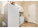 Bright laundry room with white cabinetry, tile flooring, and ample storage space at 2457 E Melrose St, Mesa, AZ 85213