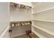 Walk-in closet with a rod and shelf storage system and a dark-stained wood floor at 2457 E Melrose St, Mesa, AZ 85213