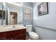 Half bathroom featuring a single vanity with a sink and a toilet with a grab bar and framed print at 25806 W Hilton Ave, Buckeye, AZ 85326