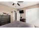 Neutral bedroom featuring a ceiling fan, TV, closet, and dresser for ample storage at 25806 W Hilton Ave, Buckeye, AZ 85326