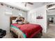 Bedroom with a ceiling fan, red bedspread, and sports-themed decorations on the walls and ceiling at 25806 W Hilton Ave, Buckeye, AZ 85326