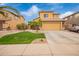 Two-story home features a desert landscaped front yard, two-car garage and stone accents at 25806 W Hilton Ave, Buckeye, AZ 85326