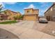 View of a two-story home with desert landscaping, palm trees, and a two-car garage at 25806 W Hilton Ave, Buckeye, AZ 85326