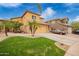 Tan two-story home with desert landscaping and a covered car in the driveway at 25806 W Hilton Ave, Buckeye, AZ 85326