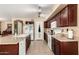 Bright kitchen with granite countertops, tile floors, and dark wood cabinets and a kitchen island at 25806 W Hilton Ave, Buckeye, AZ 85326