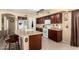 Well-appointed kitchen featuring wooden cabinets, granite countertops, and a kitchen island with bar seating at 25806 W Hilton Ave, Buckeye, AZ 85326