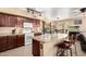 Functional kitchen with wood cabinets, granite counters, a central island, and convenient access to the dining area at 25806 W Hilton Ave, Buckeye, AZ 85326
