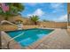 Sparkling pool with safety railing and lush landscaping, creating a serene outdoor oasis at 25806 W Hilton Ave, Buckeye, AZ 85326