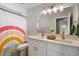 Bright bathroom featuring a double sink vanity, modern fixtures, and a colorful shower curtain at 2604 N 27Th St # 4, Phoenix, AZ 85008