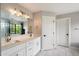 Modern bathroom with dual sinks, quartz countertops, and a large mirror with stylish lighting over marble-like tile floors at 2604 N 27Th St # 4, Phoenix, AZ 85008