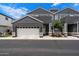 Stylish gray two-story townhome featuring an attached two-car garage and manicured landscaping, set under a partly cloudy blue sky at 2604 N 27Th St # 4, Phoenix, AZ 85008